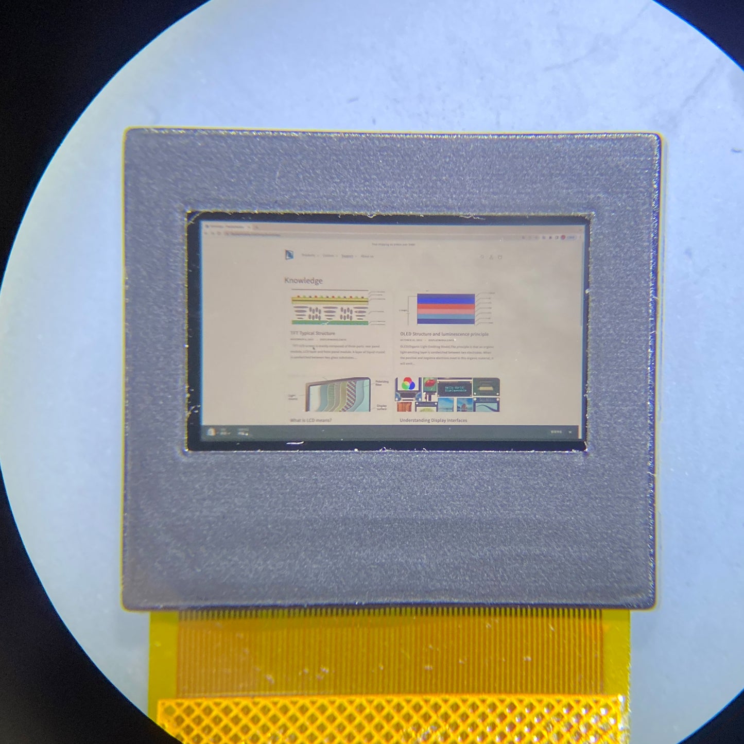 A Micro OLED display under a microscope, displaying a webpage on it